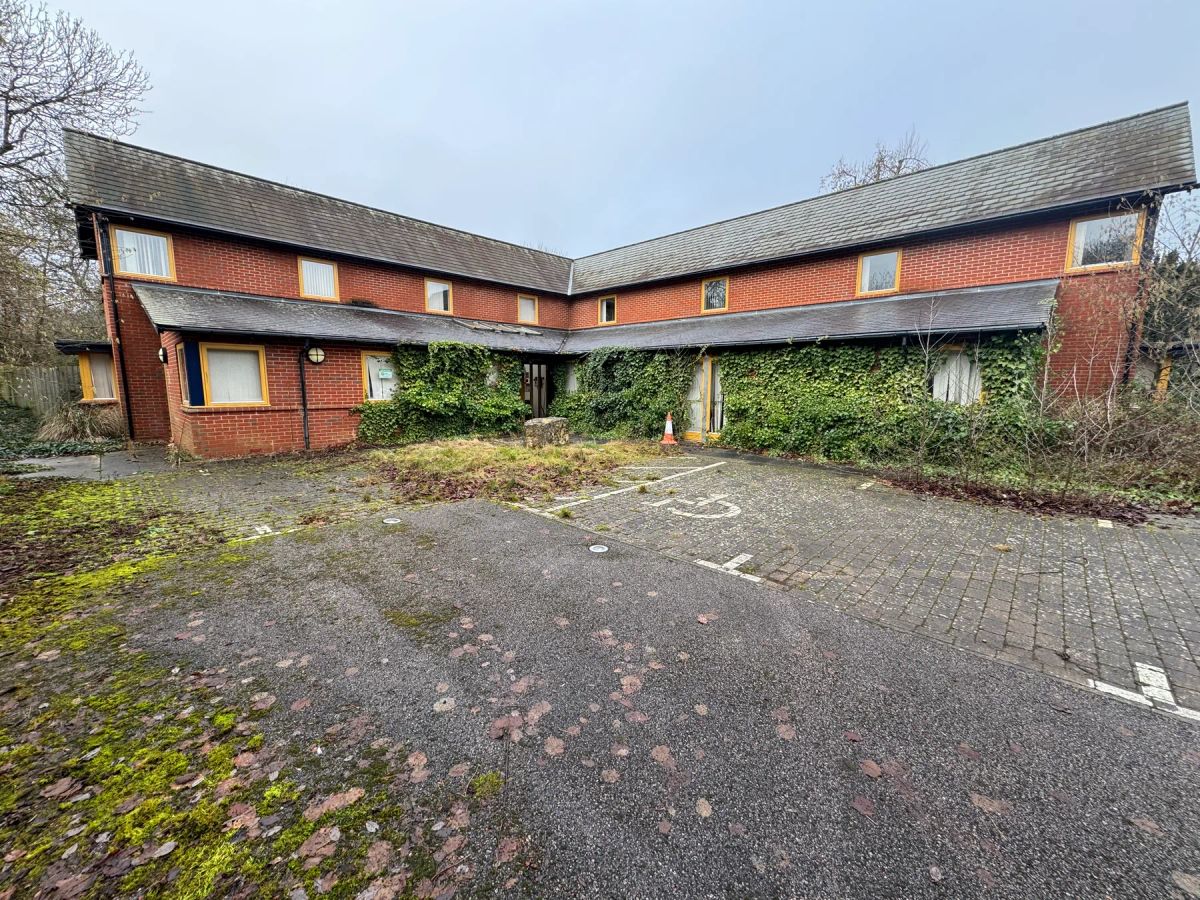 The building before the renovation, overgrown with ivy