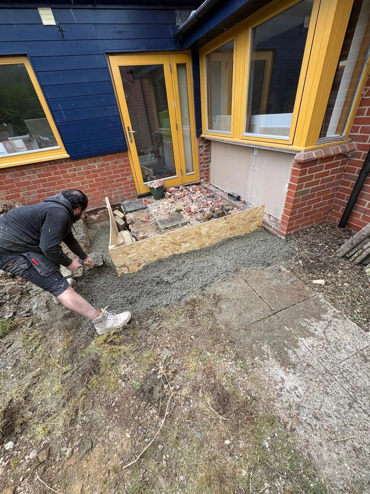 Laying concrete for a new entrance outside the yellow doors